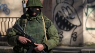 An armed man stands near a Ukrainian military base in Simferopol