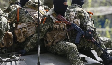 Armed men drive an armoured personnel carrier in Slaviansk
